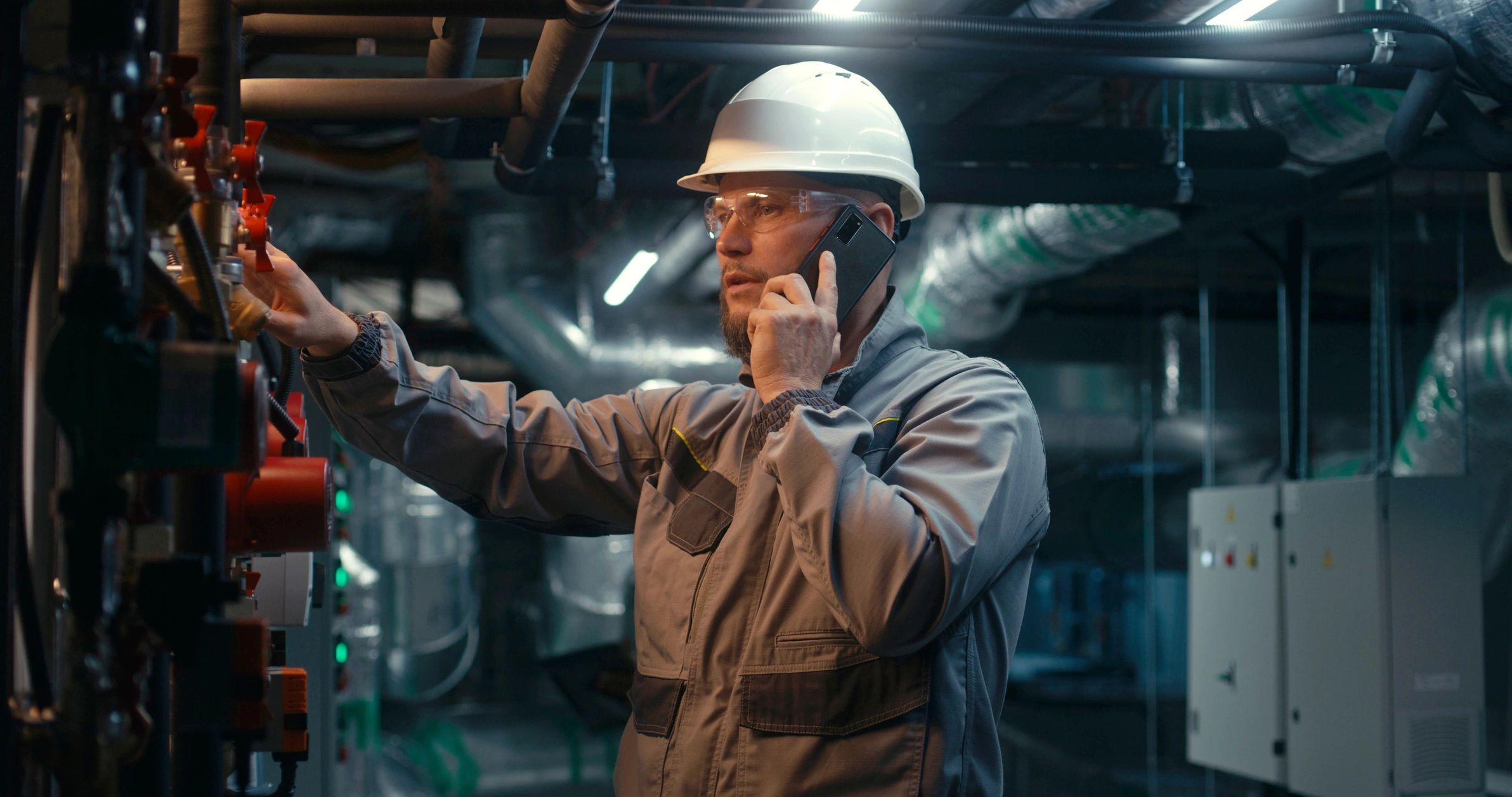 Field engineer using a phone at an industrial facility